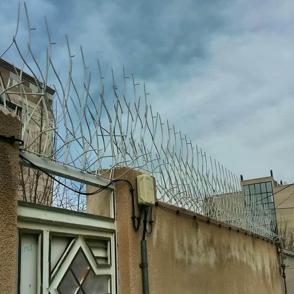 نرده سرنیزهای مشکی نصب شده بر دیوار آجری نرده سرنیزهای مشکی نصب شده بر دیوار آجری