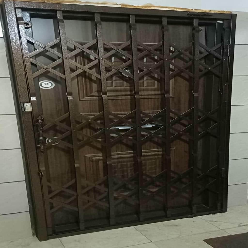 نمای نزدیک دستگیره نقره‌ای روی گارد کشویی سفید