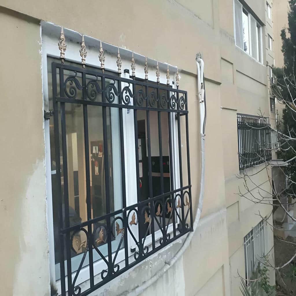 گارد پنجره سفید روی نمای آجری در استان کرمانشاه
